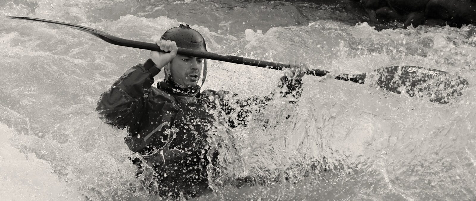 Photo by Eduard Labár man in black jacket holding a stick in water