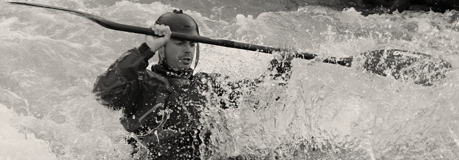 Photo by Eduard Labár man in black jacket holding a stick in water